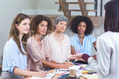 Woman giving presentation to her colleagues