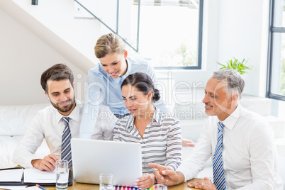 Business colleagues discussing office work on laptop
