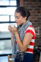 Beautiful woman smelling a cup of coffee