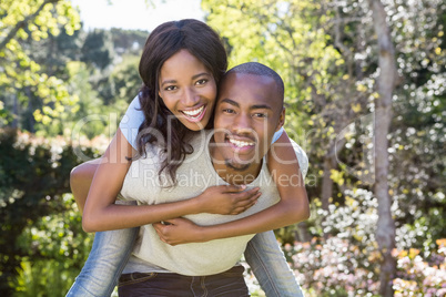 Young man giving piggyback ride to woman