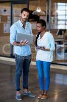 Young man and woman discuss using digital tablet and laptop