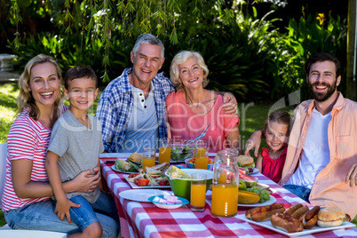 Multi-generation family enjoying breakfast in yard