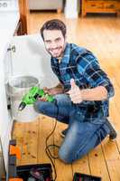 Portrait of a happy man showing his thumbs up while holding a dr