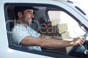 Smiling delivery man driving van