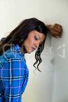 Tensed woman leaning on wall