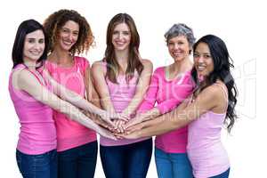 Women in pink outfits joining in a circle for breast cancer awar