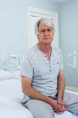 Portrait of depressed senior man sitting at home