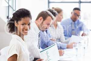 Portrait of businesswoman holding a report at meeting