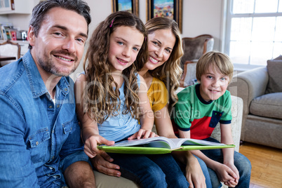 Portrait of happy family sitting on sofa with photo album