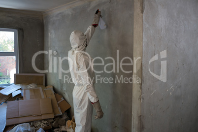 Man doing pest control on a wall