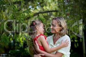 Happy mother embracing daughter in yard