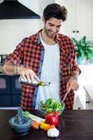 Young man preparing a salad in kitchen