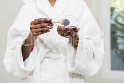 Woman holding foundation and brush