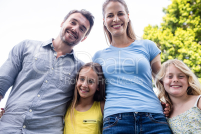 Happy family standing together with arm around