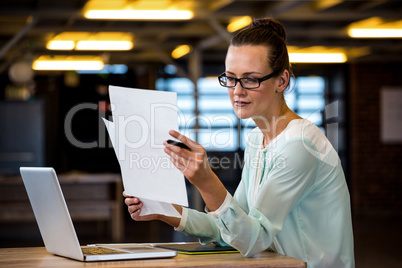 Woman reading a document in office