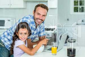 Happy man standing by daughter in kitchen at home