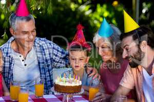 Family with birthday boy celebrating in yard