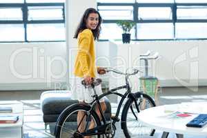 Young woman standing with bicycle