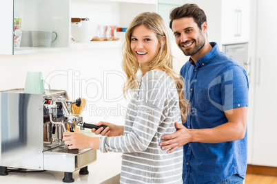 Young couple preparing coffee from coffeemaker