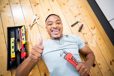 Man showing his thumbs up while working with a set of tools