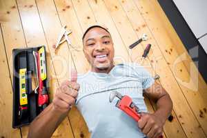 Man showing his thumbs up while working with a set of tools