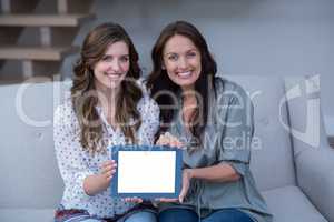 Two beautiful woman holding digital tablet