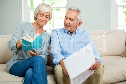 Senior couple reading book at home