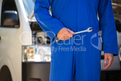 Mechanic holding spanner at the garage