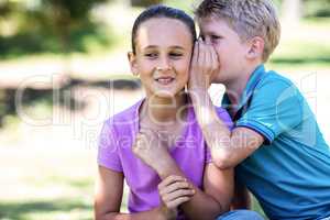 Brother whispering in his sisters ear