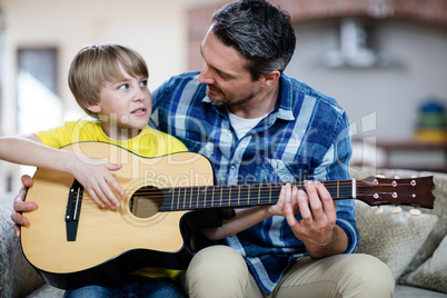 Father and son playing a guitar Father and son playing a guitar