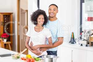 Young couple embracing in kitchen