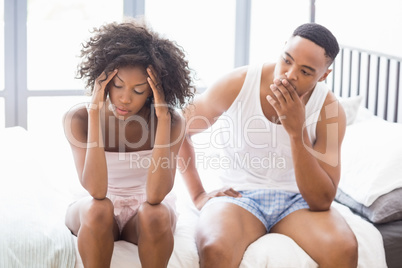 Upset couple ignoring each other after fight on bed