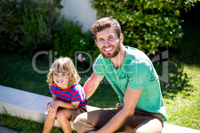 Father with son sitting in backyard