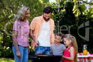 Family grilled food on barbecue at yard
