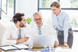 Business colleagues discussing office work on laptop