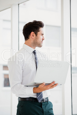 Businessman using laptop and taking notes