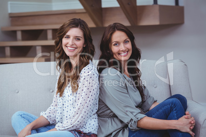 Two beautiful sitting back to back on sofa