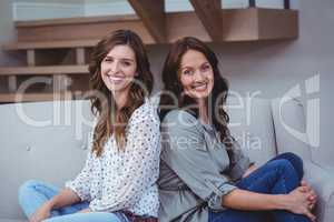 Two beautiful sitting back to back on sofa