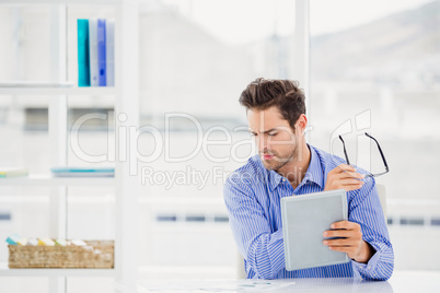 Businessman looking at document and using digital tablet