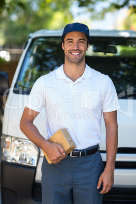 Happy delivery person holding cardboard box