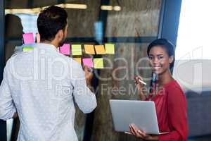 Colleagues writing on sticky notes