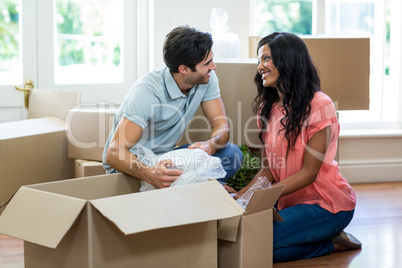 Young couple unpacking carton boxes in their new house