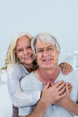 Portrait of happy senior couple hugging at home