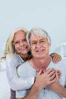 Portrait of happy senior couple hugging at home