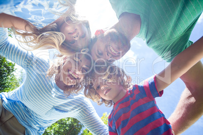 Happy parents with children forming huddle at yard