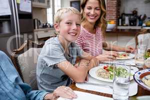 Portrait of boy having meal with his family