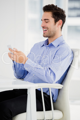 Businessman text messaging on mobile phone