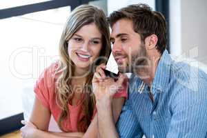 Happy couple with man talking on phone