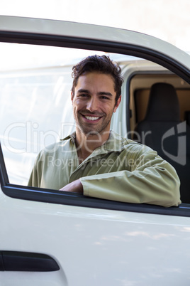 Happy pesticide worker standing by van