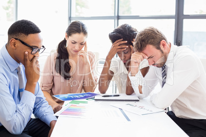 Depressed businesspeople sitting at table during a meeting